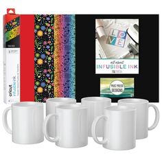 three white coffee mugs are in front of a colorful background and an insulated book