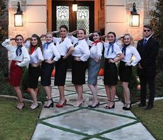 a group of people standing next to each other in front of a building with doors