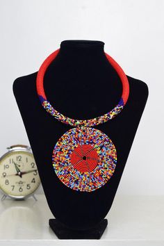 Unique African Maasai Handcrafted Beaded Necklace with an Elegant Look and Brilliant Finish.Color - Red and Mixed Color Beads.Length (Around Neck) - 17 Inches/ 43.2 Centimeters. Length (Downwards)  - 4.5 Inches / 12 Centimeters.**GET FREE SHIPPING FOR ADDITIONAL ITEMS PURCHASED.Yes, Buy Multiple Items and pay shipping for 1 item only- The rest ships Free. (No Limits on the number of Multiple items). With a faster delivery time of 3 days via DHLExpress, Worldwide. Ordinary/Standard Shipping also Traditional Red Necklace With Black Beads, Traditional Red Necklaces With Black Beads, Bohemian Red Necklace With Black Beads, Handmade Round Beaded Necklace For Festivals, Red Polished Beads Beaded Necklace For Festival, Red Bohemian Beads With Beaded Chain, Red Beaded Chain For Festivals, Red And Black Beaded Necklace For Festivals, Bohemian Beaded Round Choker