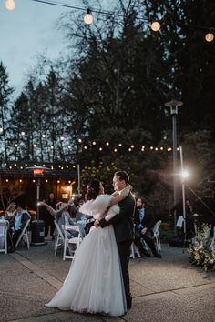 a bride and groom sharing their first dance at the wedding reception in an outdoor venue