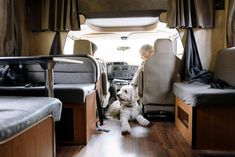 a woman and her dog are sitting in the back of an rv with bunk beds