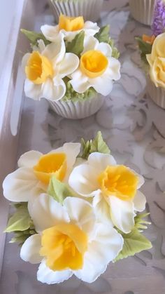 some cupcakes with yellow and white flowers in them