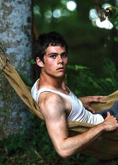 a man sitting in a hammock with his arms crossed