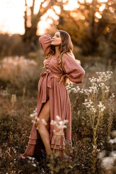 a woman is standing in the middle of a field