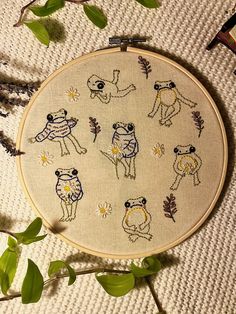 a cross stitch pattern with some animals in it on a table next to leaves and scissors