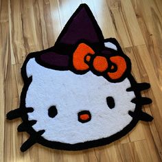 a hello kitty rug with an orange bow on it's head is laying on the floor