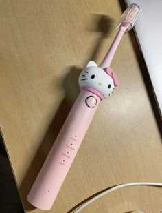 a pink hello kitty electric toothbrush sitting on top of a table