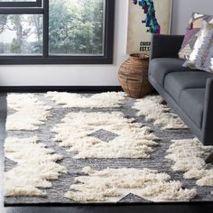 a living room with a gray couch and white rug