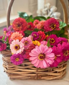 a basket filled with lots of pink and orange flowers