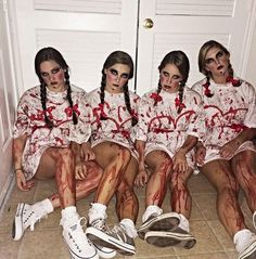 five people dressed in zombie costumes sitting on the floor with blood all over their bodies