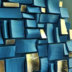 a blue wall with gold foiled squares on it and a light shining in the background