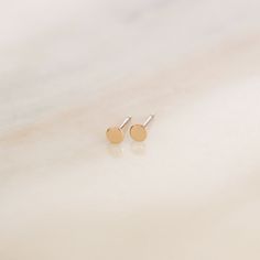 These tiny dot studs are a wonderful everyday staple! We hand cut, solder, and polish each earring to order, so we can make them in five different metal options. DETAILS * Sold as a pair with matching backings. * Dot measures 3mm across. * Available in 14k Gold Filled, 14k Rose Gold Filled, Sterling Silver, Solid 14k Yellow Gold or Solid 14k Rose Gold. * This listing is for (1) pair of dot earrings. The other items seen in the collection photos can be purchased separately via the links below. Lace Choker: https://etsy.me/2JQhwnk Medium Everyday Hoops: https://etsy.me/330gZIi Lana Pearl Necklace: https://etsy.me/2K5NAoy Lana Pearl Drops: https://etsy.me/317589E Handcrafted to order in our Salt Lake City studio ✨ . . . . . . . . . . . . . . . . . . . . .  A B O U T * U S * A N D * O U R * P Dot Earrings, Studs Gold, Gift Wrap Box, Lace Choker, Jewelry Dainty, Dainty Studs, Tiny Earrings, Pearl Drop, Minimalist Earrings