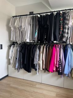 a closet filled with lots of clothes and shirts hanging on the wall next to each other