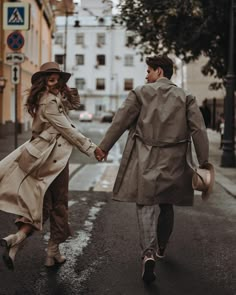 a man and woman walking down the street holding hands