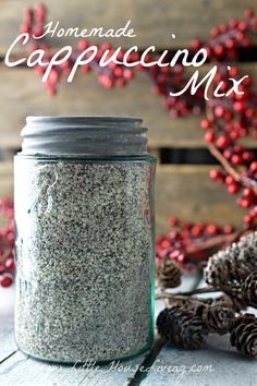 a jar filled with sand next to pine cones