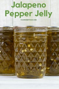 jars filled with jalapeno pepper jelly on a white counter top and the words jalapeno pepper jelly above them