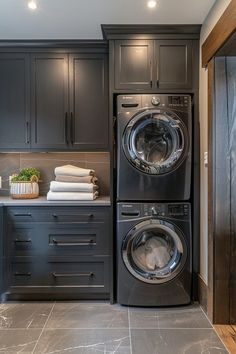 a washer and dryer in a kitchen with dark cabinets on either side of the washer