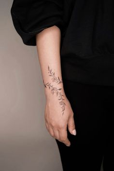 a woman's arm with a small tattoo on the left side of her wrist