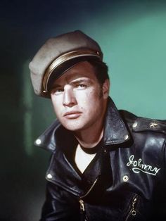 a man wearing a leather jacket and hat