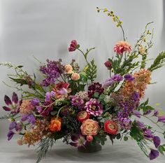 a vase filled with lots of different colored flowers