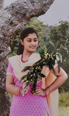 a woman standing in front of a tree