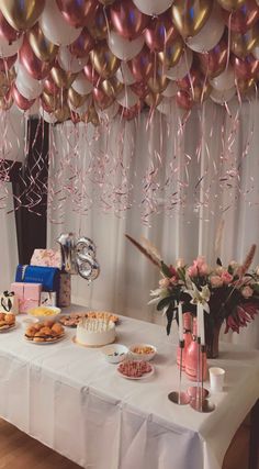 a table topped with lots of food and balloons