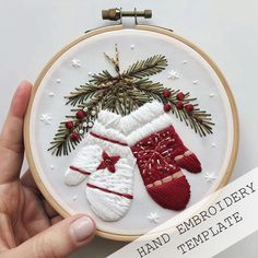 a hand embroidered christmas stocking and mittens ornament on a hoop frame