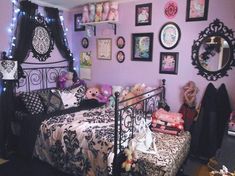 a bedroom decorated in black and pink with pictures on the wall above the bed, teddy bears sitting at the foot of the bed