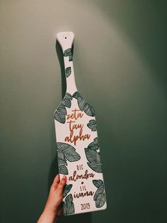 a hand holding up a ceramic bottle shaped like a leaf with the words, etana aloha written on it