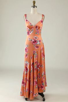 an orange dress with pink flowers on it and a white mannequin behind it