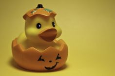 an orange rubber ducky with a jack - o'- lantern on its head