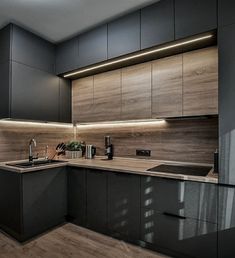 a kitchen with grey cabinets and wooden counter tops is lit by recessed lighting above the sink