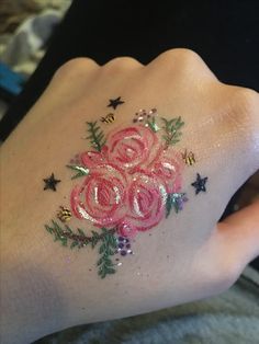 a woman's arm with flowers and stars on it