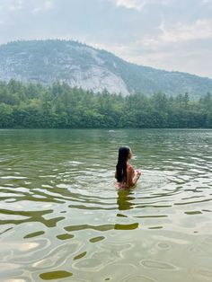 a woman is sitting in the water with her back turned