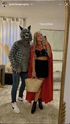 a man and woman in costumes taking a selfie with a cat costume on the mirror