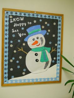 a snowman is hanging on the wall next to a potted plant