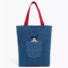 a mickey mouse denim tote bag with a red handle and pocket on the front