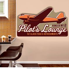 an airplane sign is hanging in the corner of a room with chairs and a table