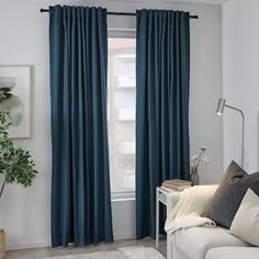 a living room with blue curtains and a white couch