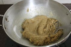 a metal bowl filled with batter on top of a stove