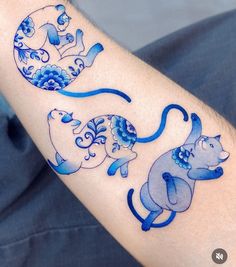 an artistic tattoo on the arm of a man with blue ink and watercolors