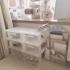 an organized desk with clear drawers and plastic containers