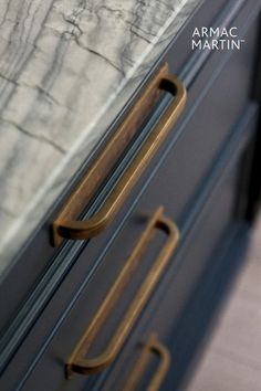 a close up of a door handle on a metal cabinet with marbled walls in the background