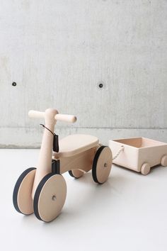 a wooden toy tricycle sitting on top of a white table next to a wall