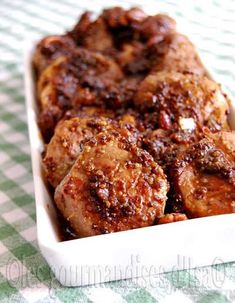 some meat in a white dish on a green and white checkered table cloth