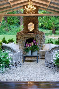 an outdoor fireplace surrounded by wicker furniture