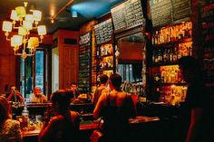 a group of people sitting at tables in a bar