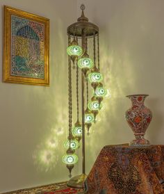 a chandelier with many lights on it next to a painting and vases