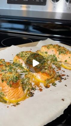 baked salmon fillets with herbs and lemons on a baking sheet in front of an oven