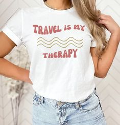 Travel Is my Therapy Shirt, Retro Travel Shirt, Vacation Shirt, Wanderlust Shirt, Funny Travel Shirt, Travel Shirt, Gift For Traveler Need a new and trendy t-shirt for your next vacay? You've come to the right place!  -SIZING  I recommend using the size chart provided to ensure you are getting the best, most accurate fit for you. For an oversized look, please size up 1-2 sizes. -MATERIAL Solid colors: 100% Airlume combed & ringspun cotton Retail fit Shoulder taping Sideseamed Tearaway label Pre- White Cotton Top For Travel, Graphic Tee With Letter Print For Travel, Short Sleeve Tops With Letter Print For Travel, White Letter Print Top For Travel, Cotton Travel Tops With Letter Print, Cotton Letter Print Travel Tops, White Summer Tops For Travel, Cotton Letter Print Tops For Travel, Casual Graphic Print Travel Shirt